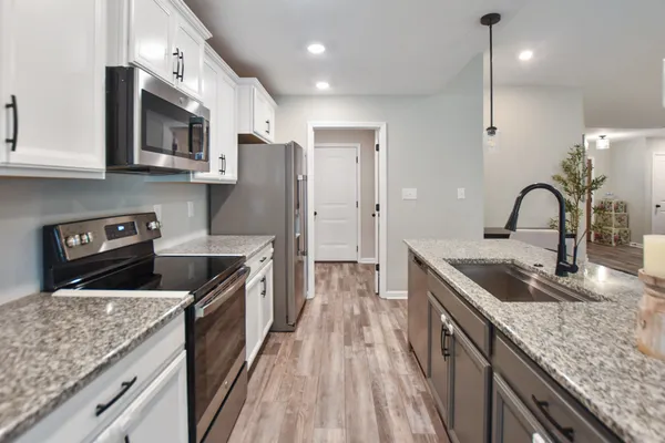 a kitchen with stainless steel appliances granite countertop a sink stove and refrigerator