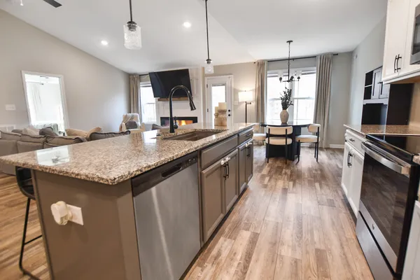 a kitchen with granite countertop kitchen island wooden floor center island and stainless steel appliances