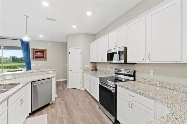 a kitchen with granite countertop white cabinets and white appliances