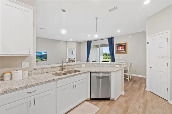 a kitchen with white cabinets and sink