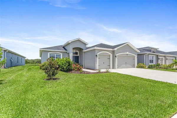 a front view of a house with a garden and yard