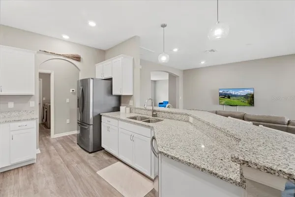 a large kitchen with stainless steel appliances kitchen island a large counter top and a wooden floors