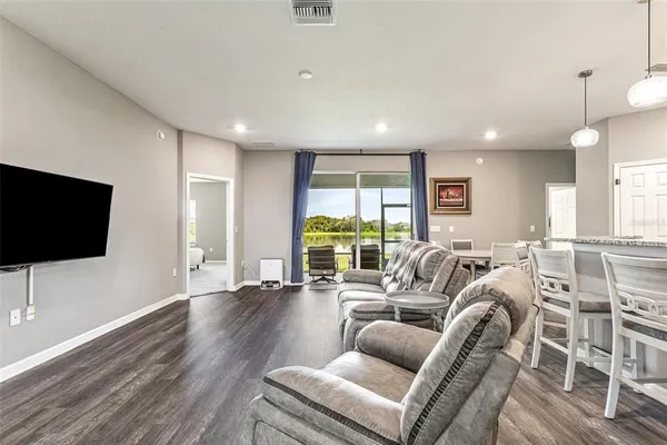 a living room with furniture a flat screen tv and a large window