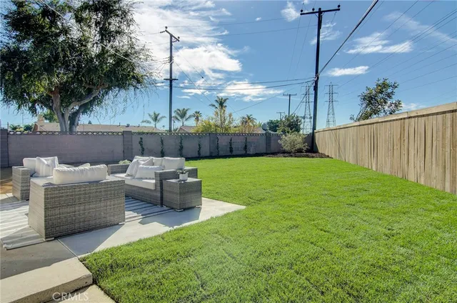 a view of a patio with couches chairs potted plants and a palm tree