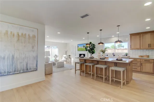 a kitchen with a dining table chairs wooden floor and appliances