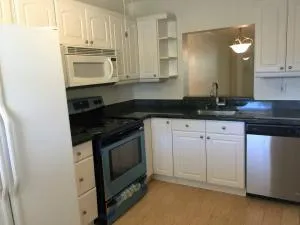 a kitchen with granite countertop white cabinets and black appliances