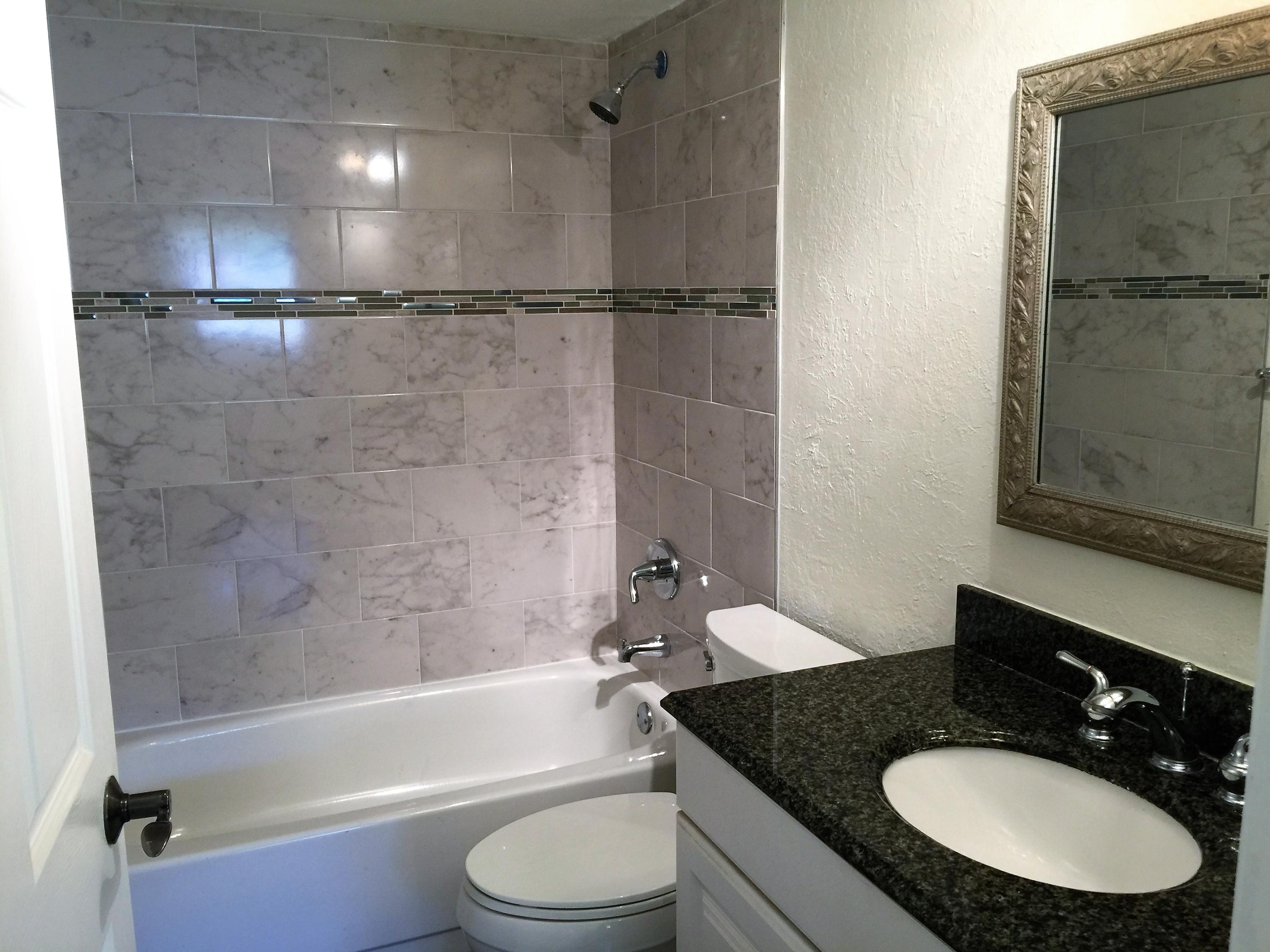 2805 Southwest 22nd Avenue, Unit 2060 Delray Beach, FL 33445 - Photo 3 of 11 a bathroom with a granite countertop shower sink vanity mirror and toilet