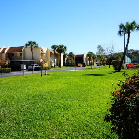 a view of a house with a big yard and large trees