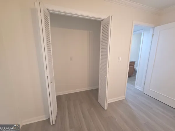 an empty room with wooden floor and closet