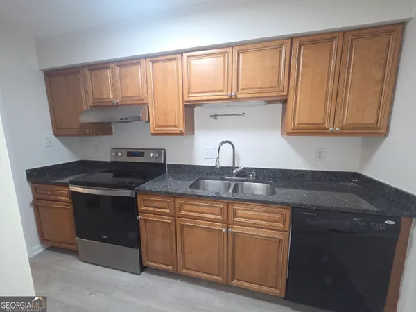 a kitchen with stainless steel appliances granite countertop a sink stove and cabinets