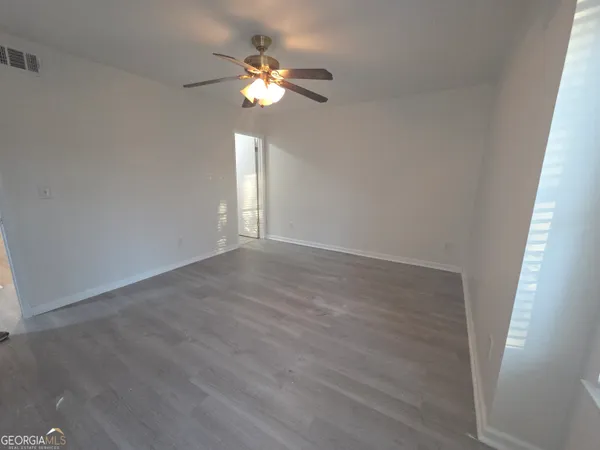 a view of an empty room with a chandelier fan