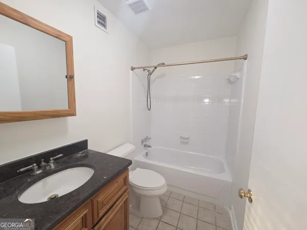 a bathroom with a granite countertop sink toilet a shower and a mirror