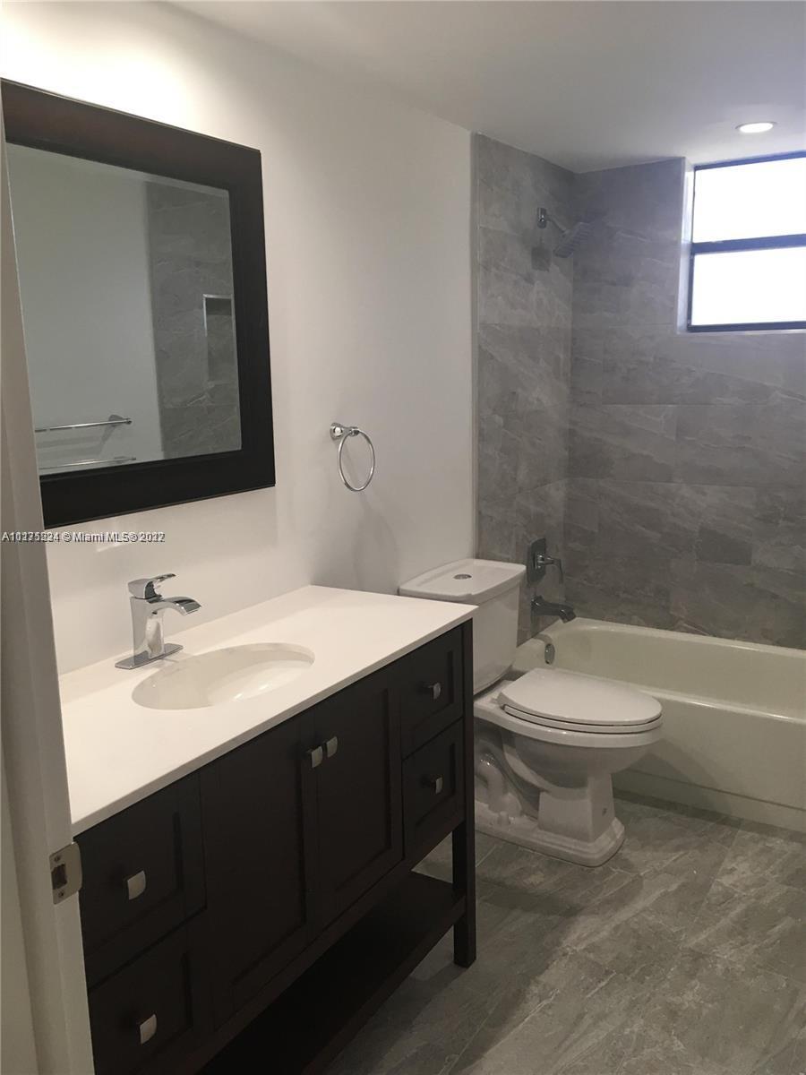 7915 Southwest 86th Street, Unit 723 Miami, FL 33143 - Photo 11 of 14 a bathroom with a toilet a sink a tub and a mirror