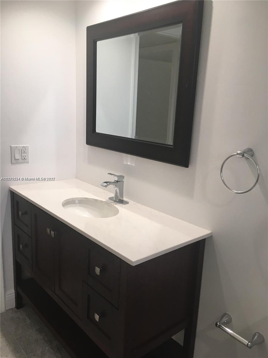 7915 Southwest 86th Street, Unit 723 Miami, FL 33143 - Photo 12 of 14 a bathroom with a sink vanity and a mirror