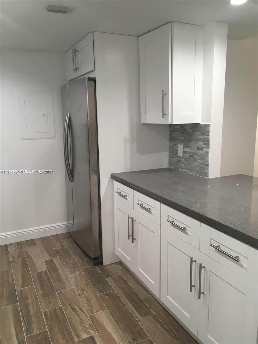 7915 Southwest 86th Street, Unit 723 Miami, FL 33143 - Photo 3 of 14 a kitchen with white cabinets and refrigerator