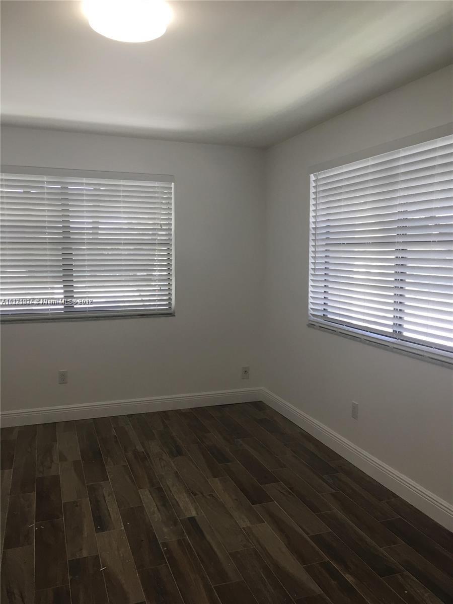 7915 Southwest 86th Street, Unit 723 Miami, FL 33143 - Photo 6 of 14 wooden floor and window in an empty room