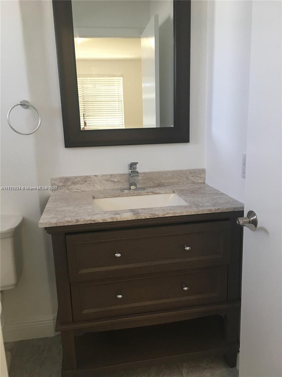 7915 Southwest 86th Street, Unit 723 Miami, FL 33143 - Photo 8 of 14 a bathroom with a sink and a mirror
