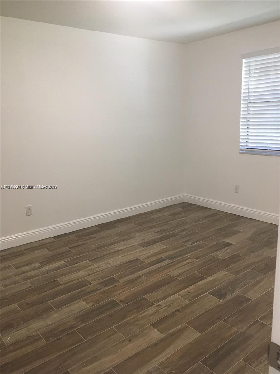 7915 Southwest 86th Street, Unit 723 Miami, FL 33143 - Photo 10 of 14 a view of a room with wooden floor and window