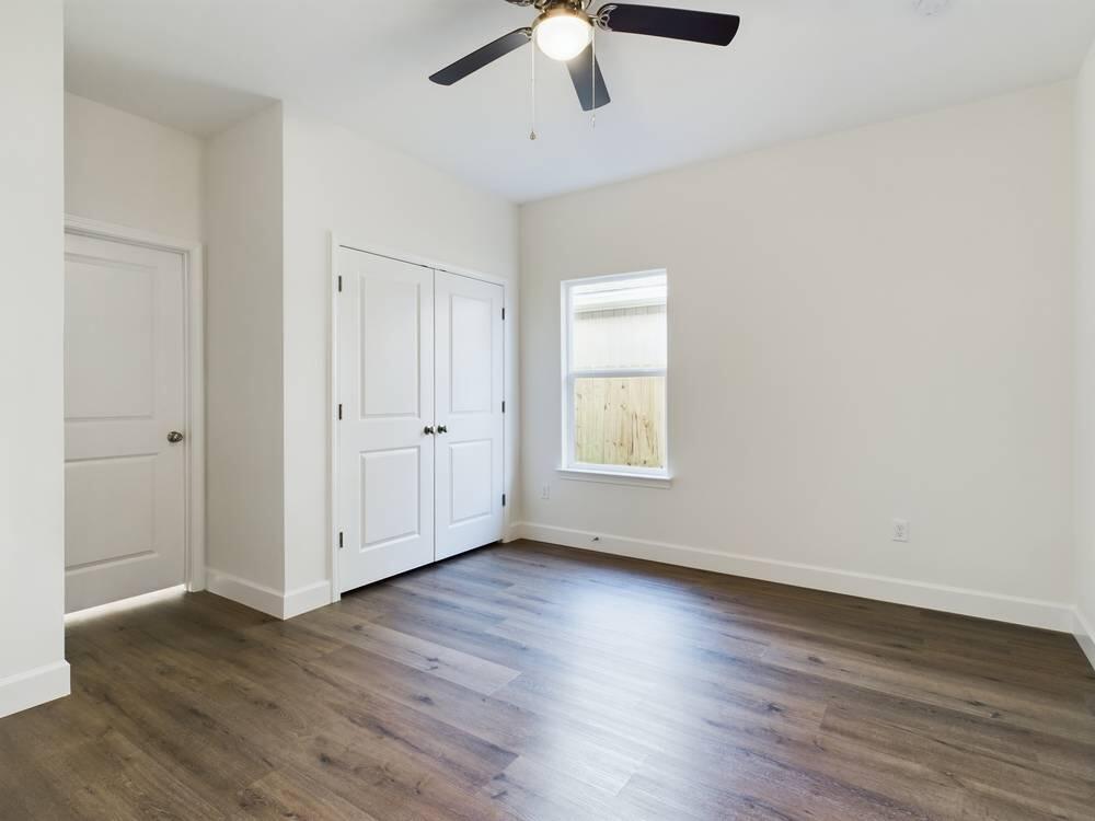 21 D 5th Avenue Shalimar, FL 32579 - Photo 13 of 18 an empty room with wooden floor chandelier fan and windows