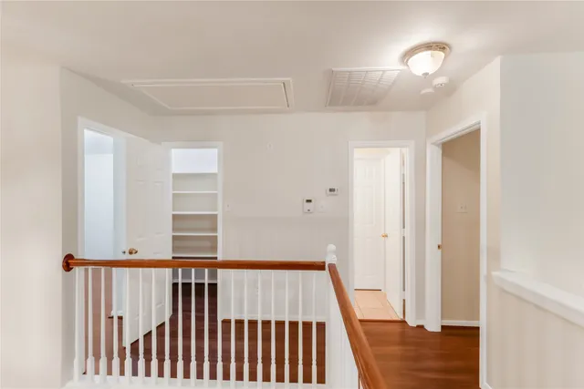 an empty room with wooden floor and ceiling fan