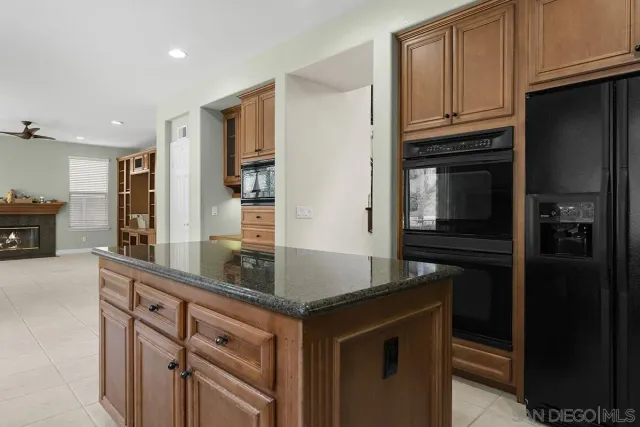 a kitchen with granite countertop a refrigerator and a sink