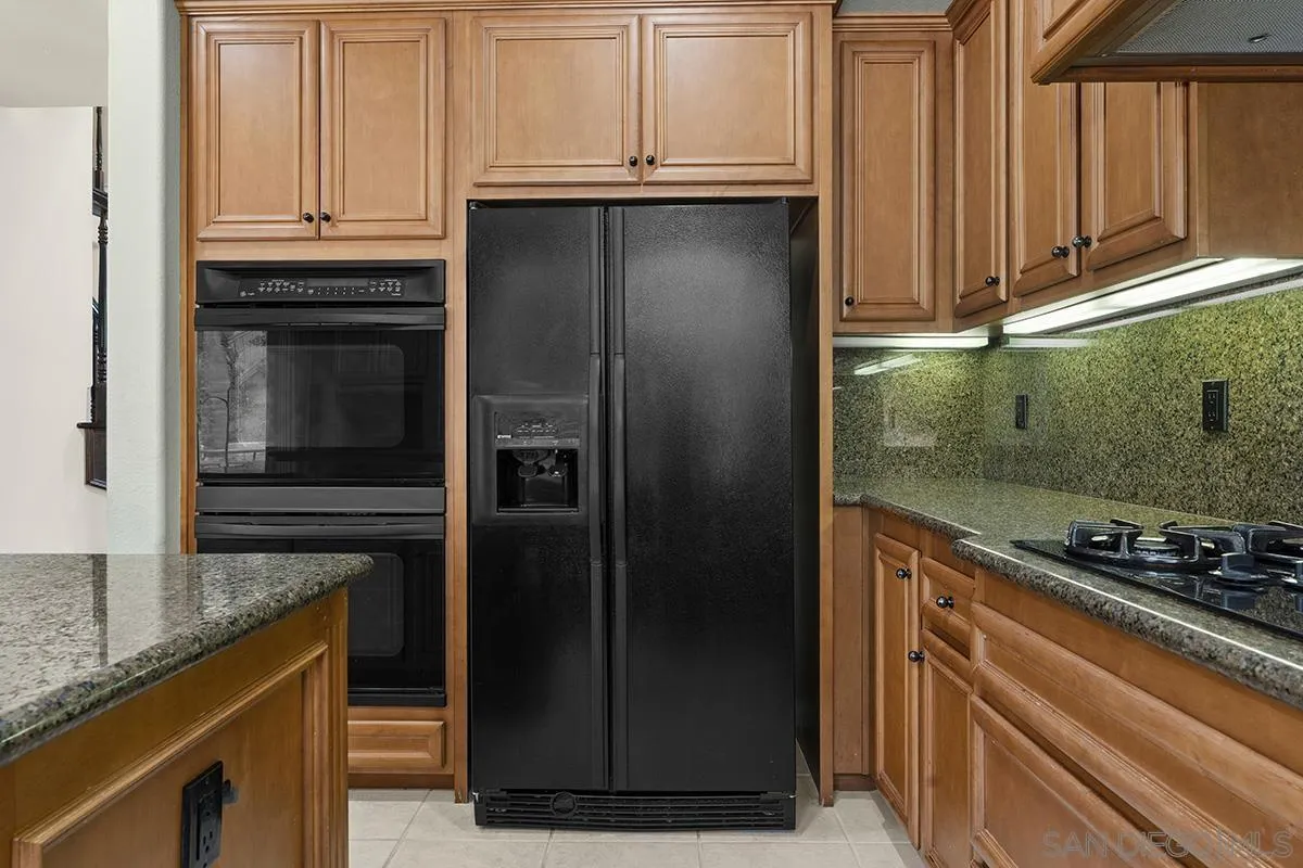 4418 Shorepointe Way San Diego, CA 92130 - Photo 16 of 65 a kitchen with granite countertop a refrigerator and a sink