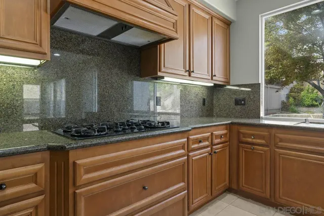 a large kitchen with granite countertop a large counter top stainless steel appliances and cabinets