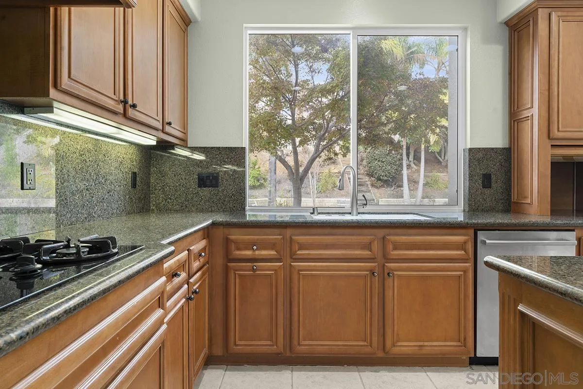 4418 Shorepointe Way San Diego, CA 92130 - Photo 19 of 65 a kitchen with stainless steel appliances granite countertop a stove and a sink