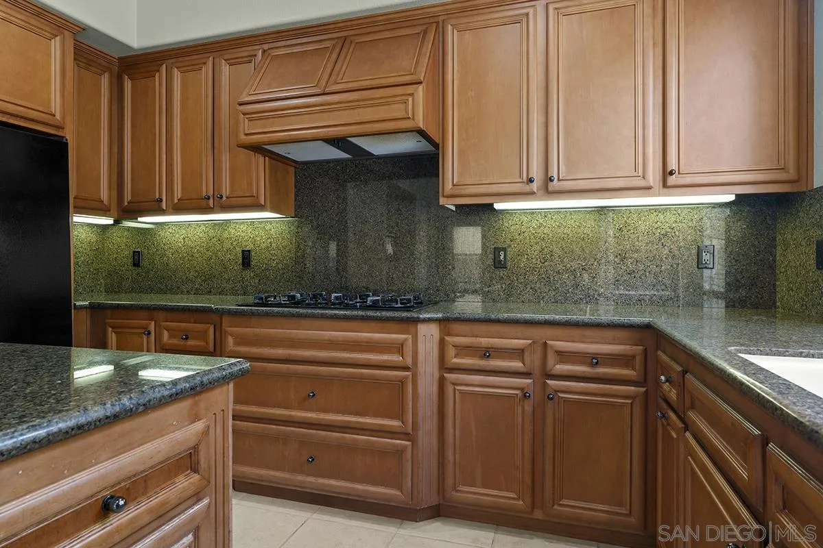 4418 Shorepointe Way San Diego, CA 92130 - Photo 20 of 65 a kitchen with stainless steel appliances granite countertop a sink and cabinets