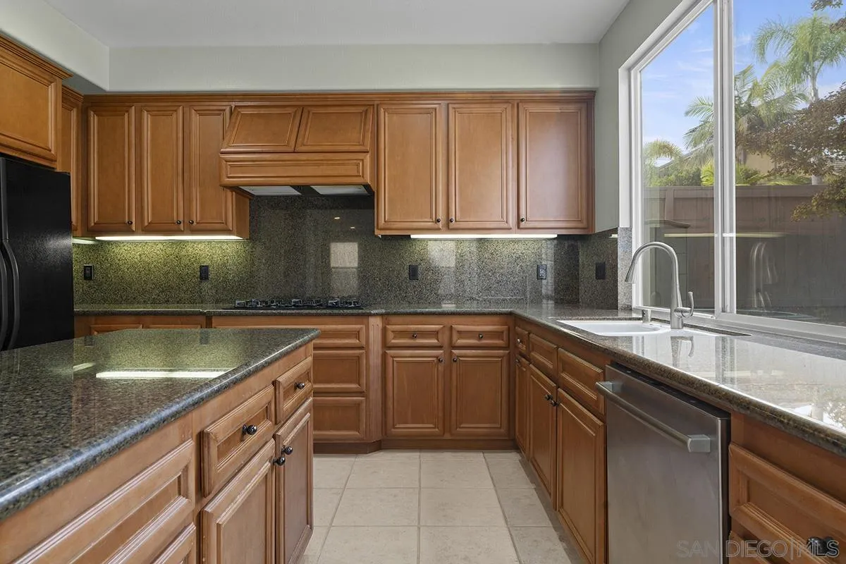 4418 Shorepointe Way San Diego, CA 92130 - Photo 21 of 65 a kitchen with a sink a counter top space cabinets and stainless steel appliances