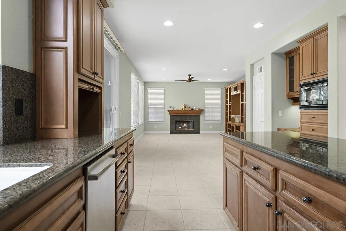 4418 Shorepointe Way San Diego, CA 92130 - Photo 22 of 65 a large kitchen with granite countertop a large counter top stainless steel appliances and cabinets