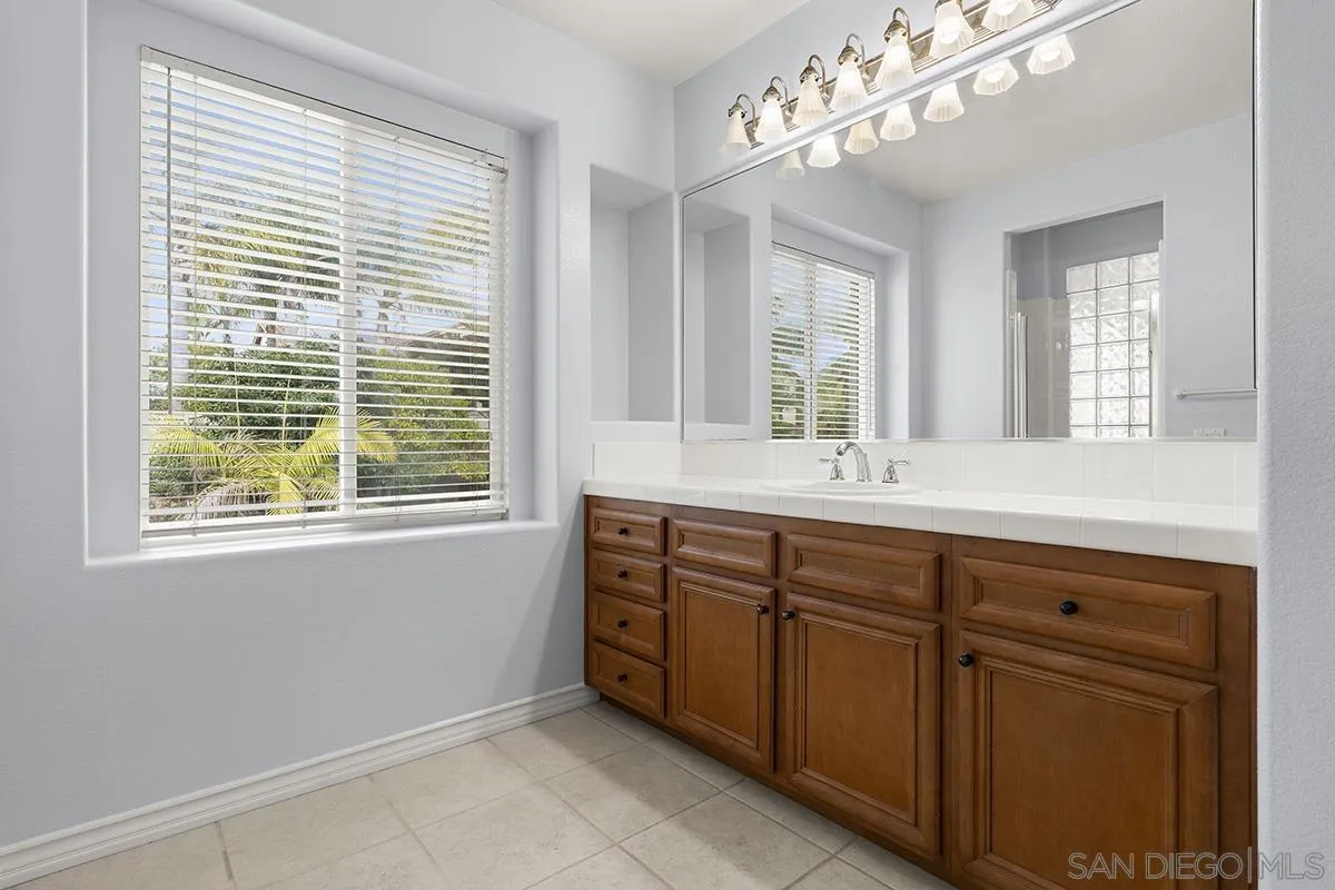 4418 Shorepointe Way San Diego, CA 92130 - Photo 41 of 65 a bathroom with double vanity sink a mirror a window and a bathtub