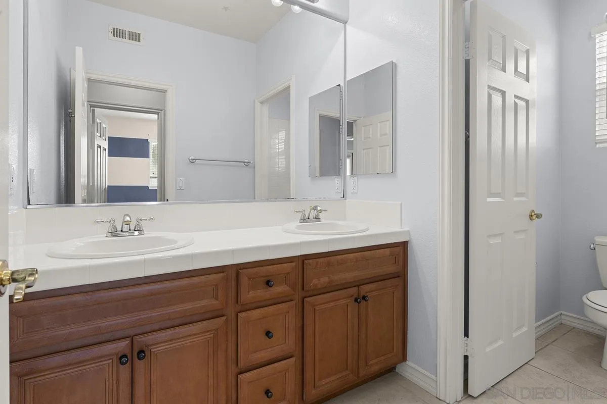 4418 Shorepointe Way San Diego, CA 92130 - Photo 48 of 65 a bathroom with a double vanity sink toilet and mirror
