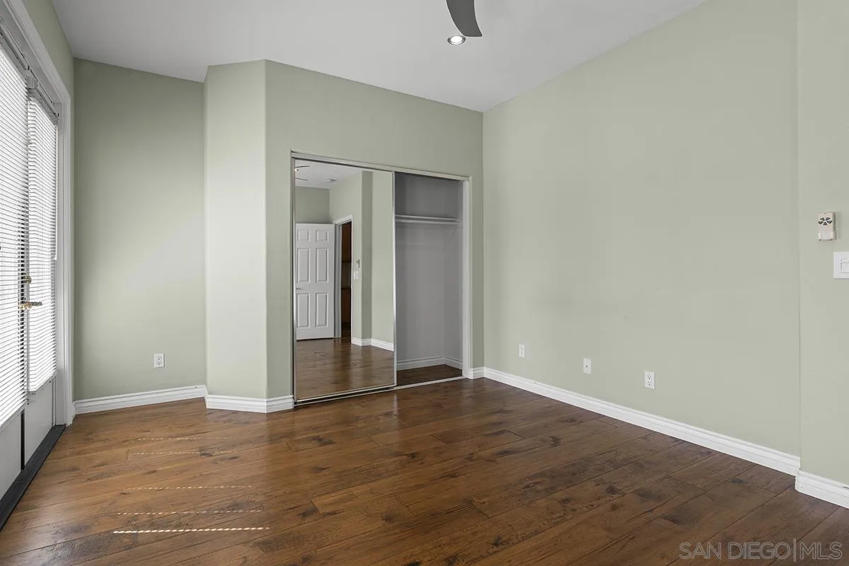4418 Shorepointe Way San Diego, CA 92130 - Photo 54 of 65 an empty room with wooden floor and windows