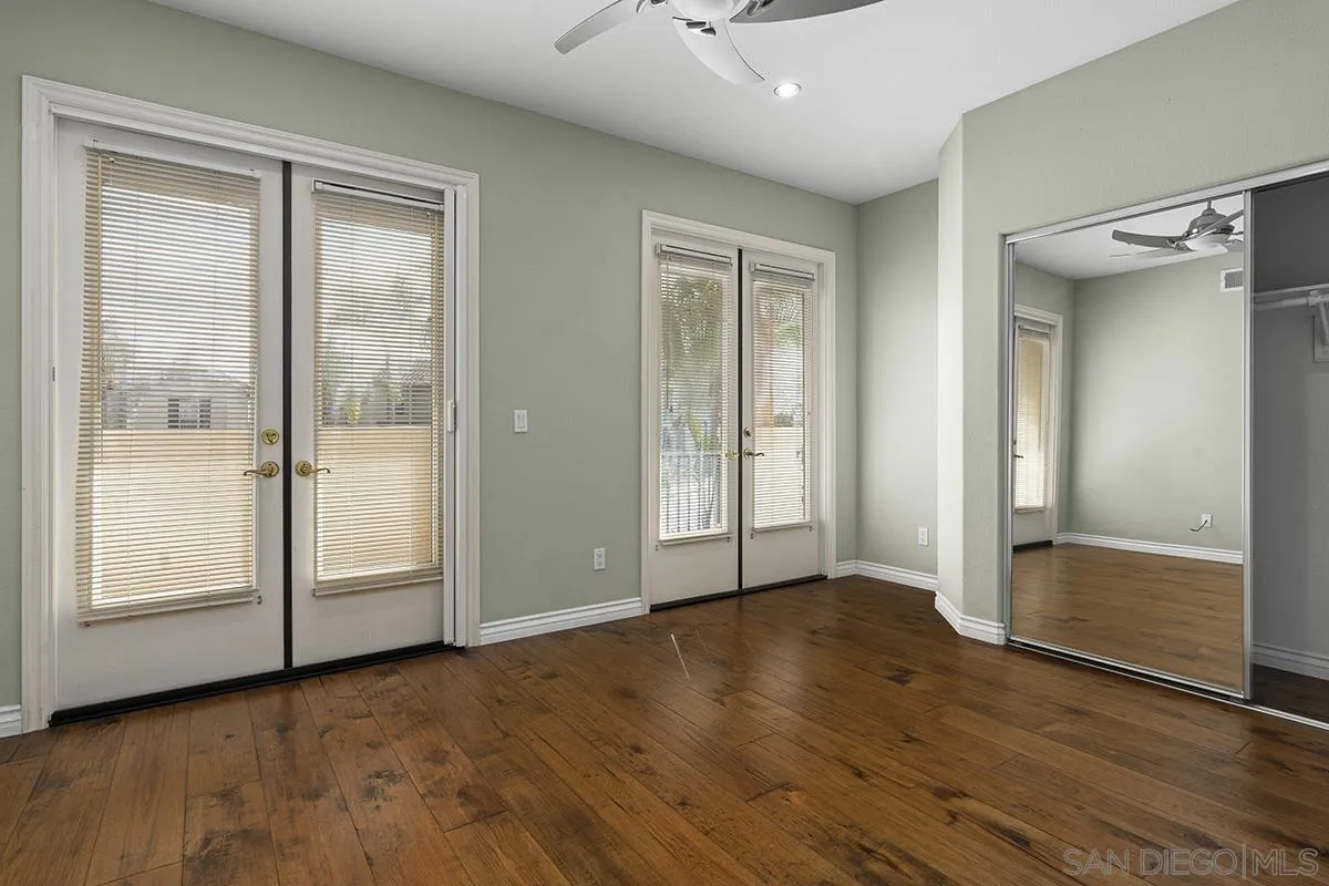 4418 Shorepointe Way San Diego, CA 92130 - Photo 55 of 65 an empty room with wooden floor mirror and windows