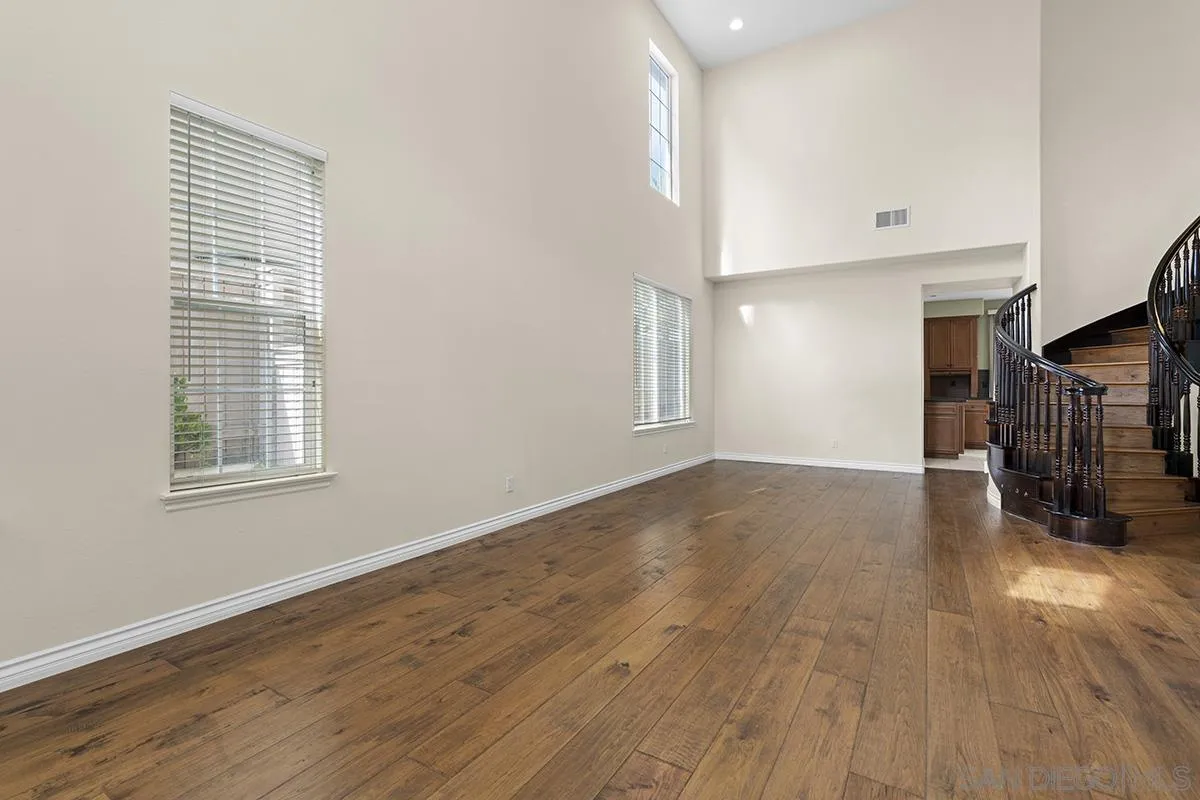 4418 Shorepointe Way San Diego, CA 92130 - Photo 9 of 65 a view of an empty room with wooden floor and a window