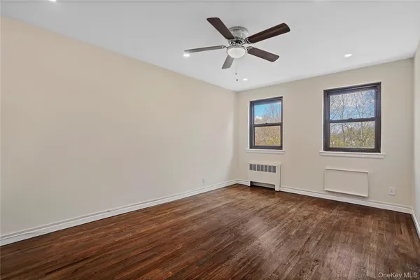 a view of a big room with wooden floor and windows