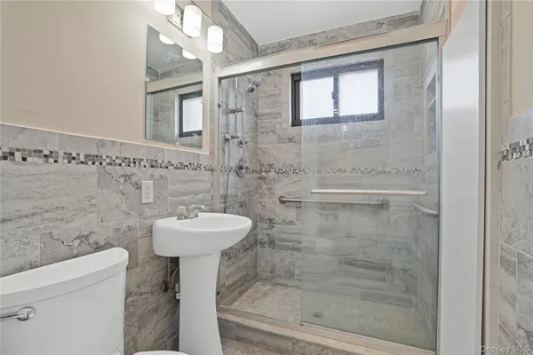 a bathroom with a sink mirror toilet and shower