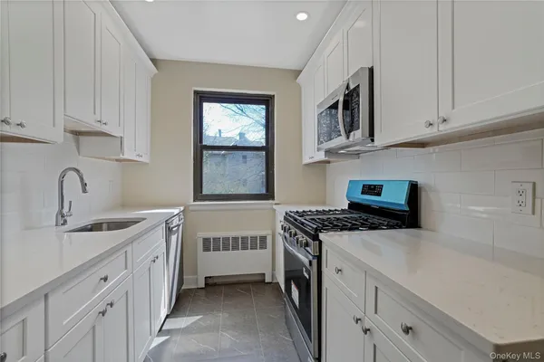 a kitchen with stainless steel appliances granite countertop a sink stove oven and white cabinets