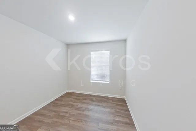 a view of a room with wooden floor and white walls
