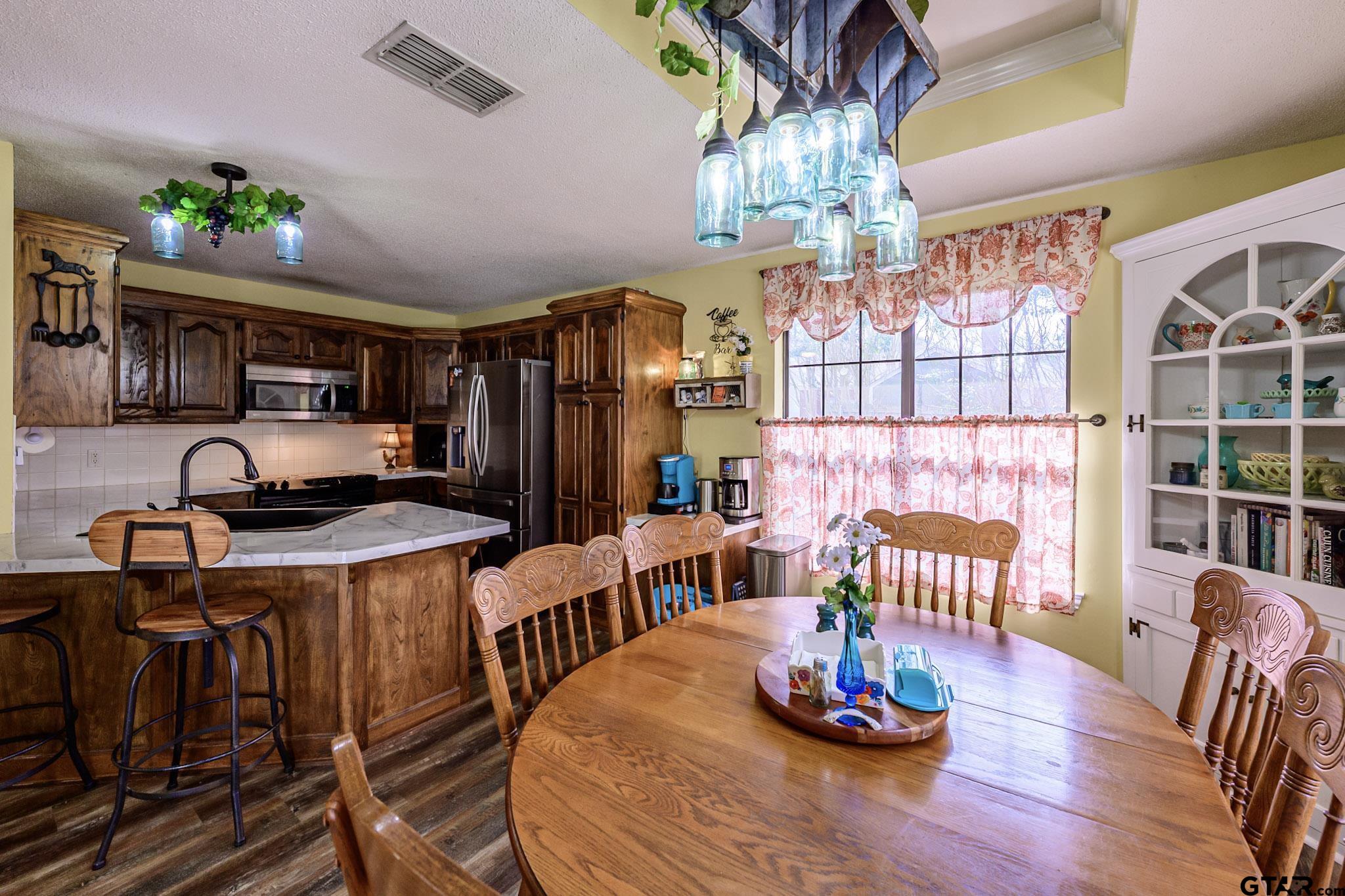 703 Kickapoo Road Chandler, TX 75758 - Photo 11 of 33 a dining room with furniture a chandelier and wooden floor