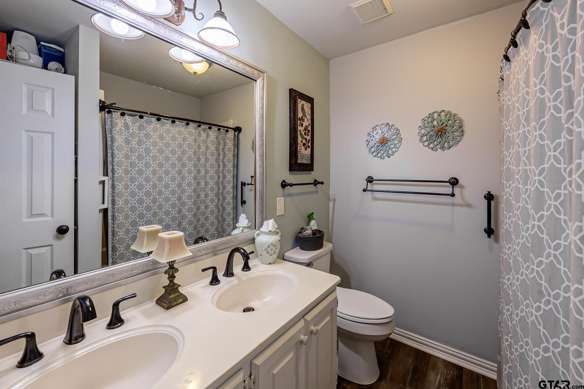 703 Kickapoo Road Chandler, TX 75758 - Photo 19 of 33 a bathroom with a sink a toilet and shower curtain