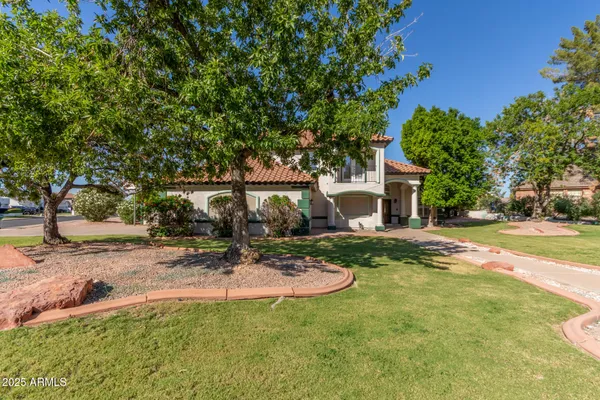 a view of a house with backyard and a tree