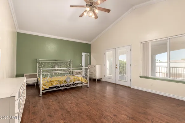 a spacious bedroom with a bed and a flat screen tv