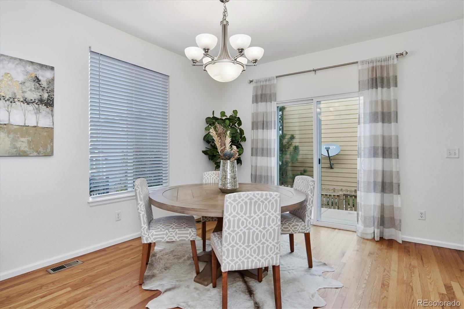 10781 Towerbridge Circle Highlands Ranch, CO 80130 - Photo 12 of 30 a view of a dining room with furniture wooden floor and a chandelier