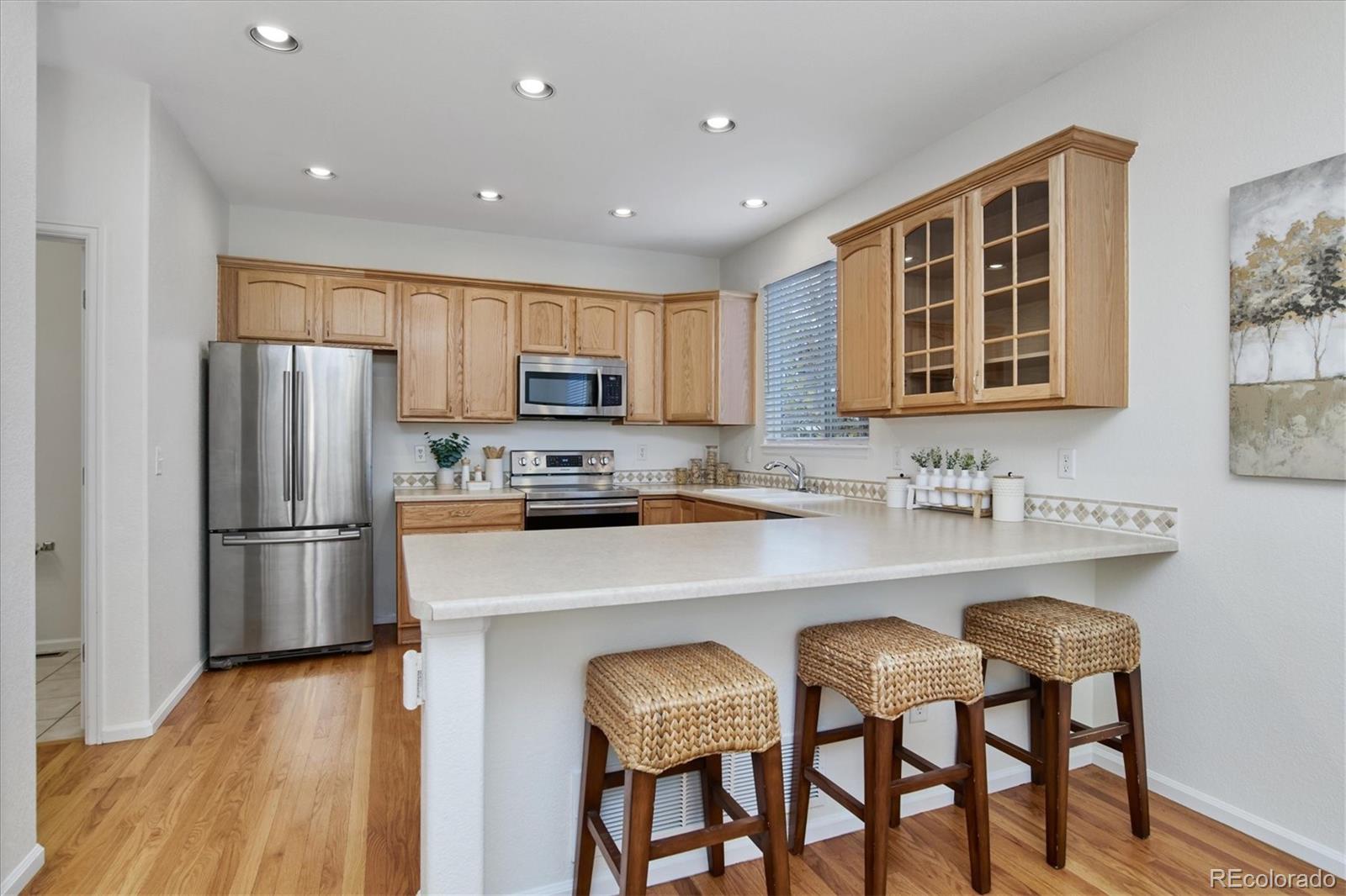 10781 Towerbridge Circle Highlands Ranch, CO 80130 - Photo 14 of 30 a kitchen with refrigerator cabinets and wooden floor