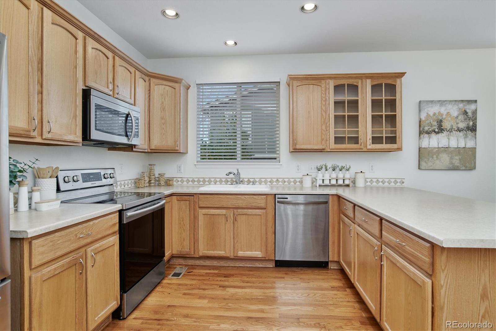 10781 Towerbridge Circle Highlands Ranch, CO 80130 - Photo 17 of 30 a kitchen with stainless steel appliances granite countertop a sink stove and cabinets