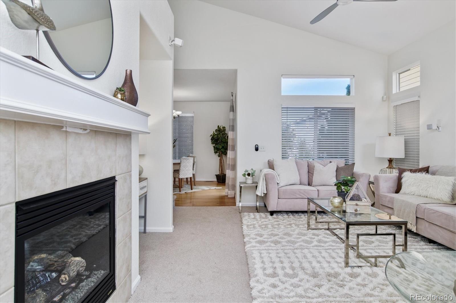 10781 Towerbridge Circle Highlands Ranch, CO 80130 - Photo 4 of 30 a living room with furniture a mirror and a fireplace