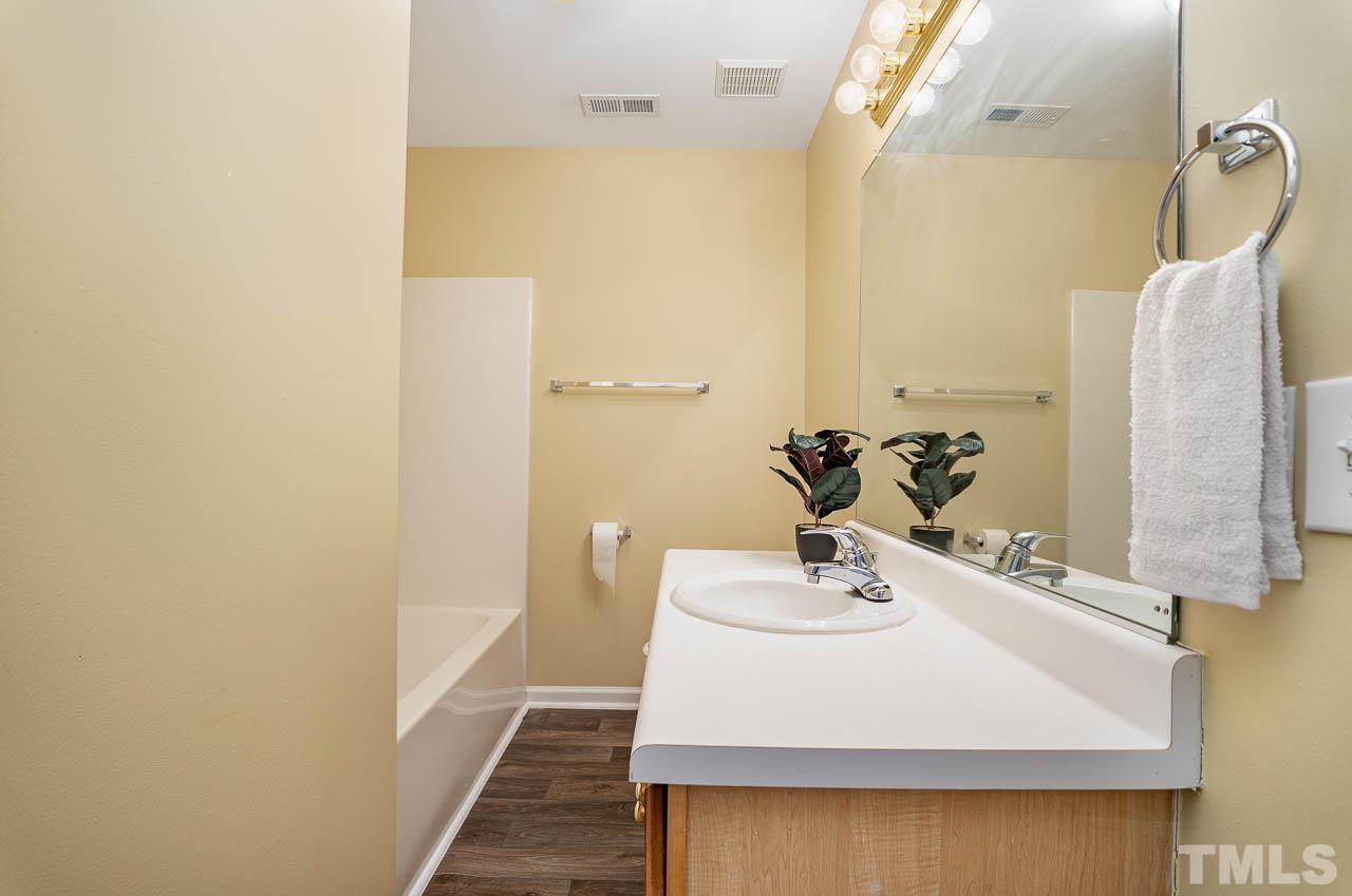 209 Dairy Road Clayton, NC 27520 - Photo 31 of 34 a bathroom with a sink a mirror and vanity