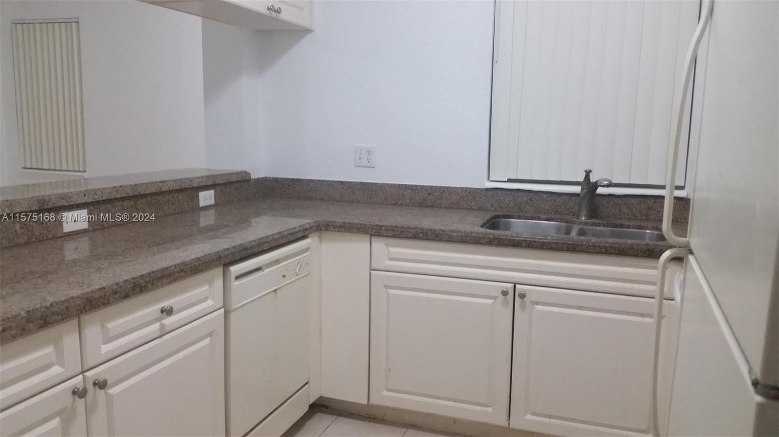 6894 West Sample Road, Unit 6894 Coral Springs, FL 33067 - Photo 7 of 18 a close view of a sink dishwasher and white cabinets